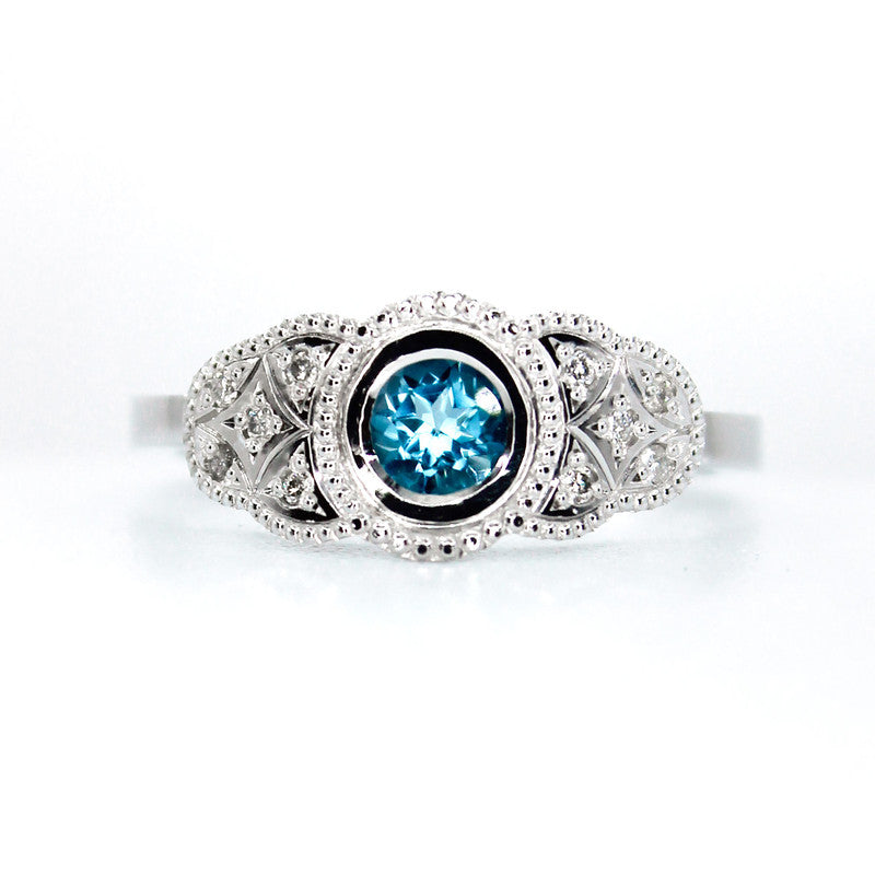 Anillo Kate en platino con zafiro azul central y diez diamantes de diseño vintage.