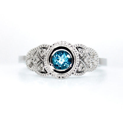 Anillo Kate en platino con zafiro azul central y diez diamantes de diseño vintage.