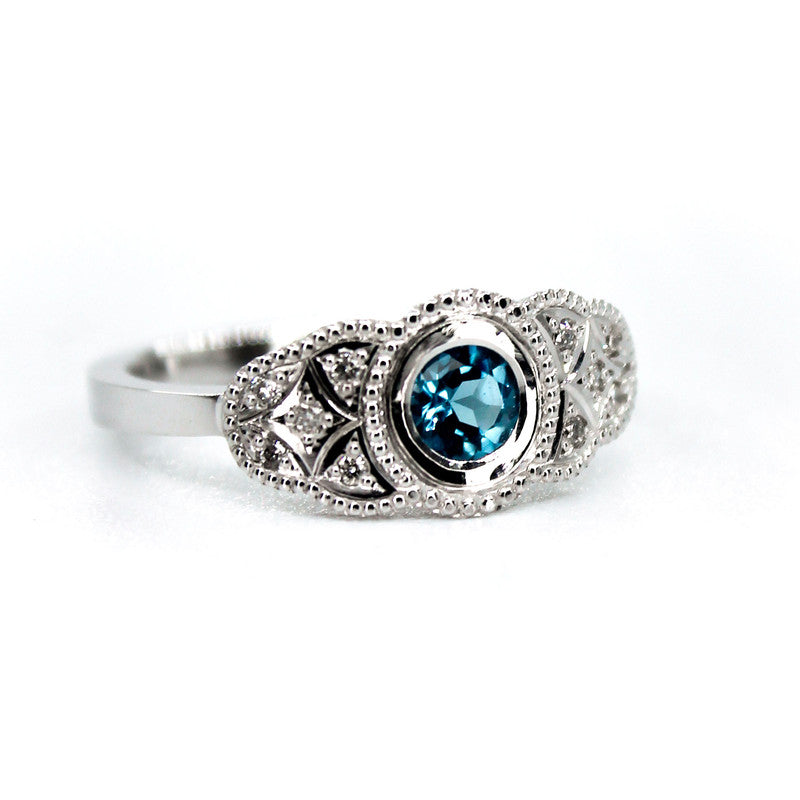 Anillo Kate en platino con zafiro azul central y diez diamantes de diseño vintage.