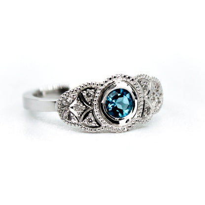Anillo Kate en platino con zafiro azul central y diez diamantes de diseño vintage.