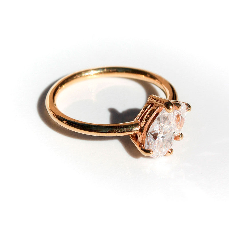 Anillo de oro amarillo 18k con dos diamantes de laboratorio corte pera de diferentes tamaños unidos en el centro.