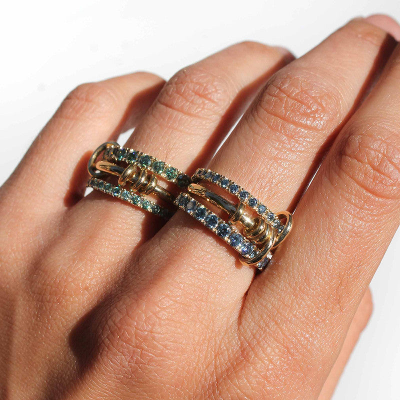 Anillo Triple Infinity en oro amarillo con moissanitas de colores y bandas móviles entrelazadas.
