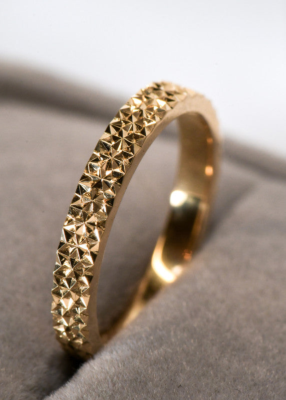 Argolla de oro con patrón geométrico grabado a mano, inspirado en la Flor de la Vida y los reflejos de la luz sobre el agua.