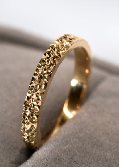 Argolla de oro con patrón geométrico grabado a mano, inspirado en la Flor de la Vida y los reflejos de la luz sobre el agua.