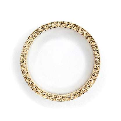 Argolla de matrimonio en oro amarillo 18k con grabado geométrico realizado a mano con buril y acabado brillante.