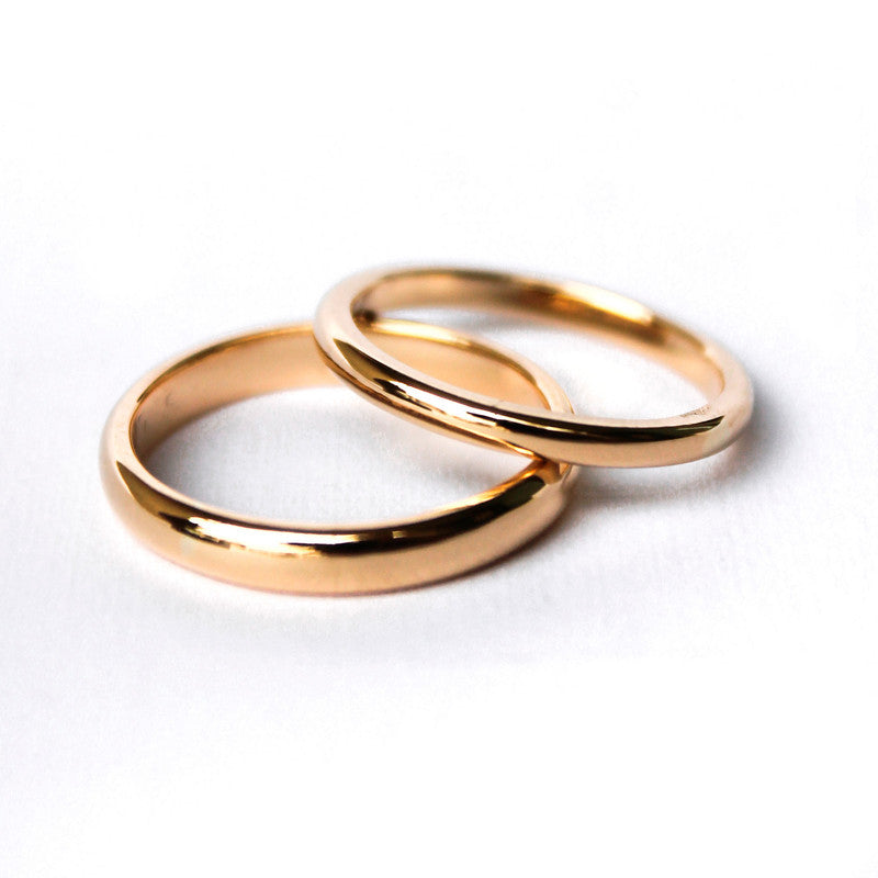 Argollas de matrimonio clasicas en oro amarillo 18k sobre fondo blanco.