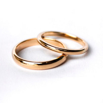 Argollas de matrimonio clasicas en oro amarillo 18k sobre fondo blanco.
