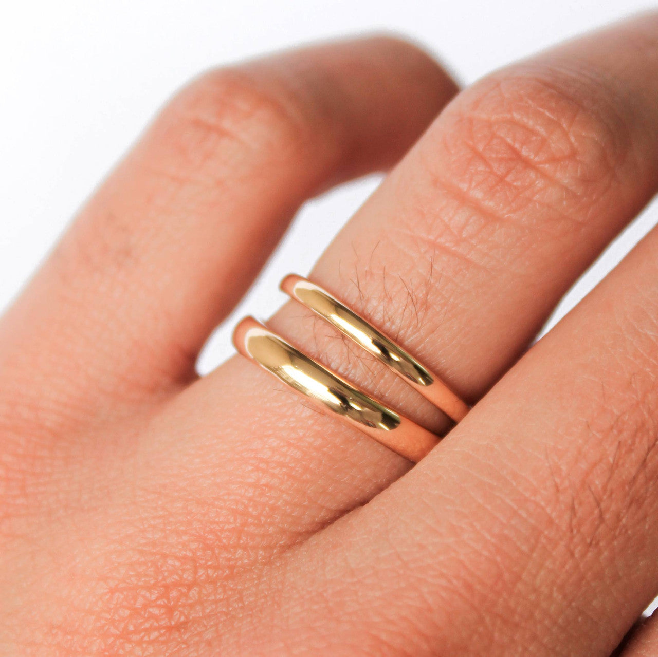Argollas de matrimonio clasicas en oro amarillo 18k sobre fondo blanco.
