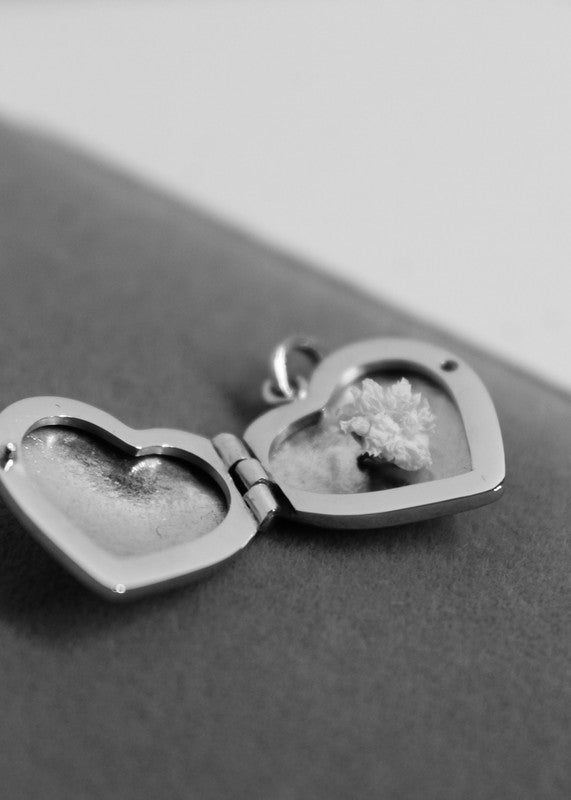 Relicario de corazón en platino hecho a mano, destinado a guardar una fotografía o un recuerdo especial.